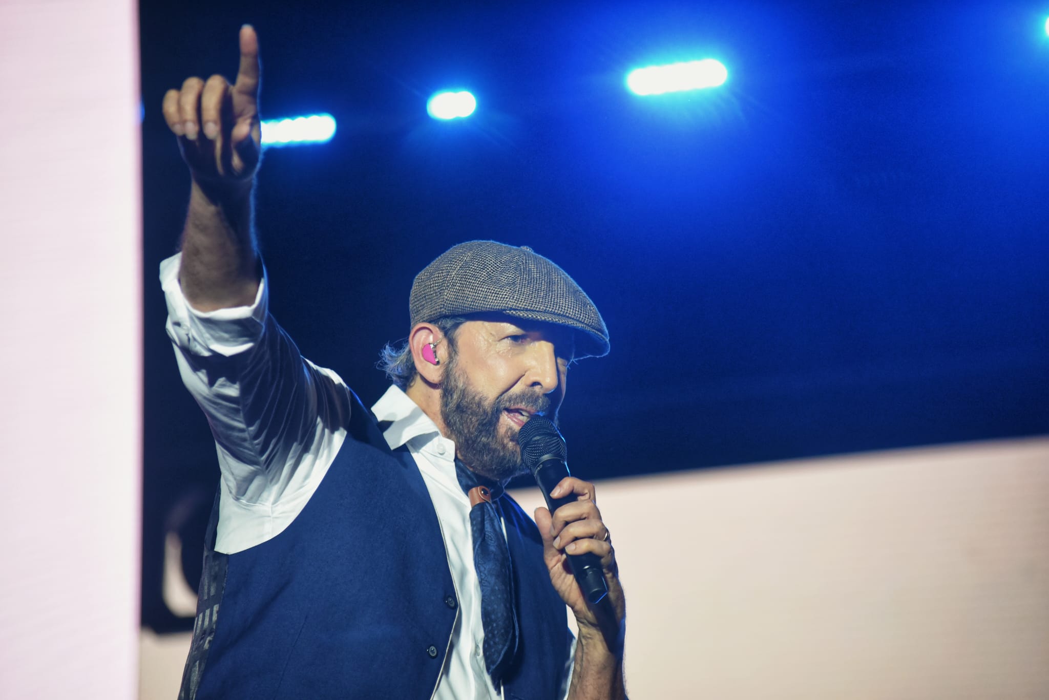 Juan Luis Guerra con el brazo alzado en el escenario de Icónica Sevilla